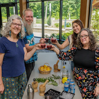 Four people standing holding a glass during the Herbal Adventure and Tour at Wellfield Botanic Gardens in Elkhart, IN.