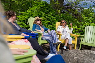 Three women sitting in colorful chairs chatting at Wellfield Botanic Gardens in Elkhart, Indiana