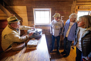 Several people standing inside Bonneyville Mill listening to the tour guide during the Streams of Power Signature Experience.
